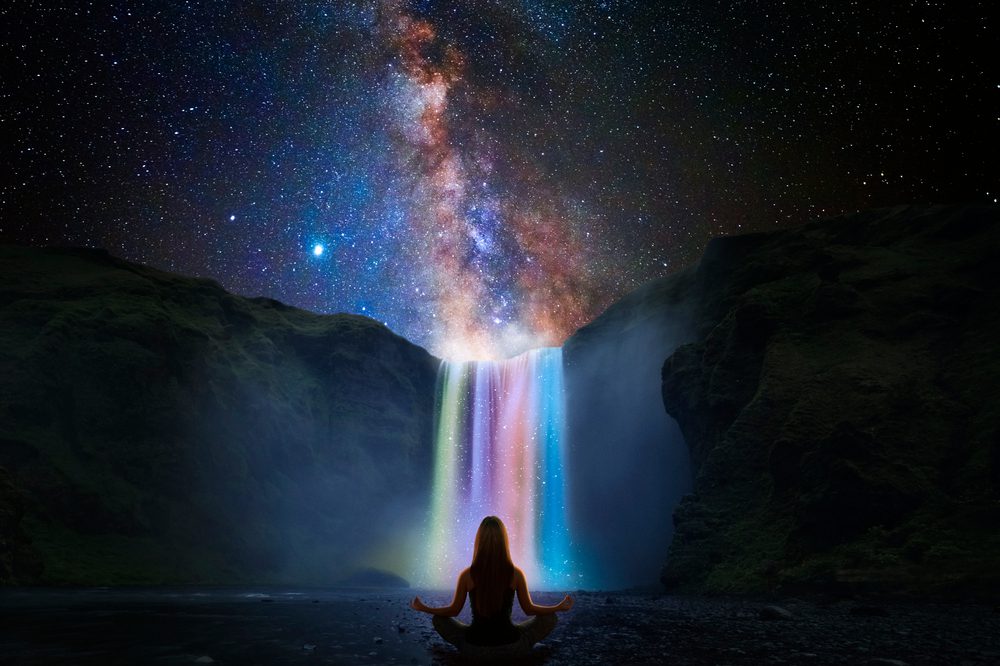 Woman,Doing,Yoga,In,Front,Of,A,Magic,Waterfall